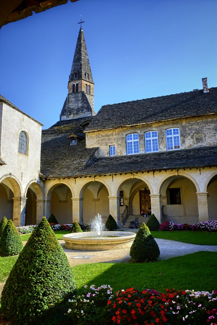 Scenic courtyard featuring a central fountain, arched walkways, and a historic tower.
