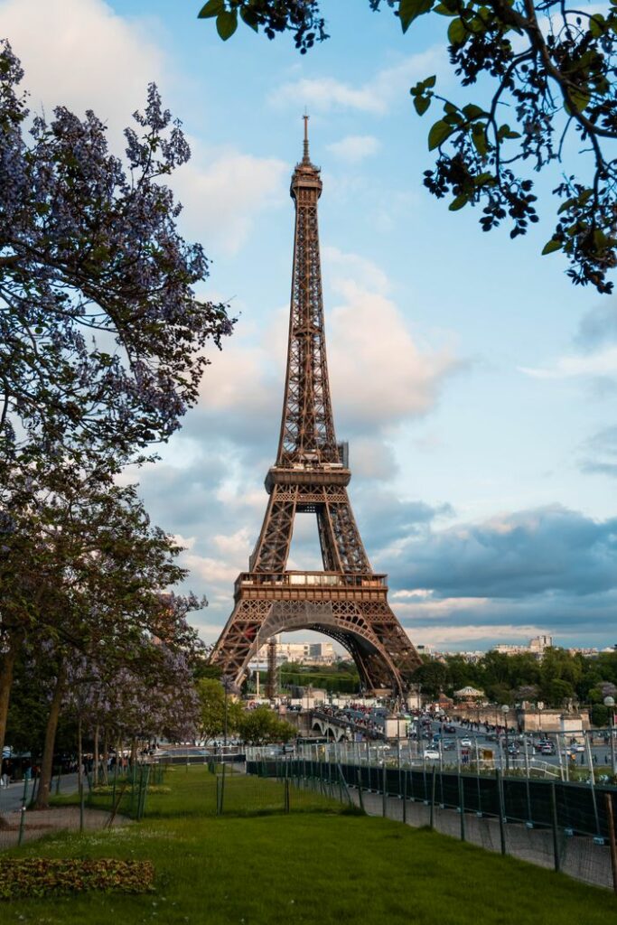 The iconic Eiffel Tower seen through blooming trees on a lovely spring day in Paris.