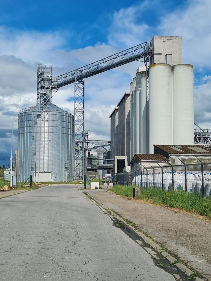 A view of industrial silos in Metz, France against a vibrant blue sky.
